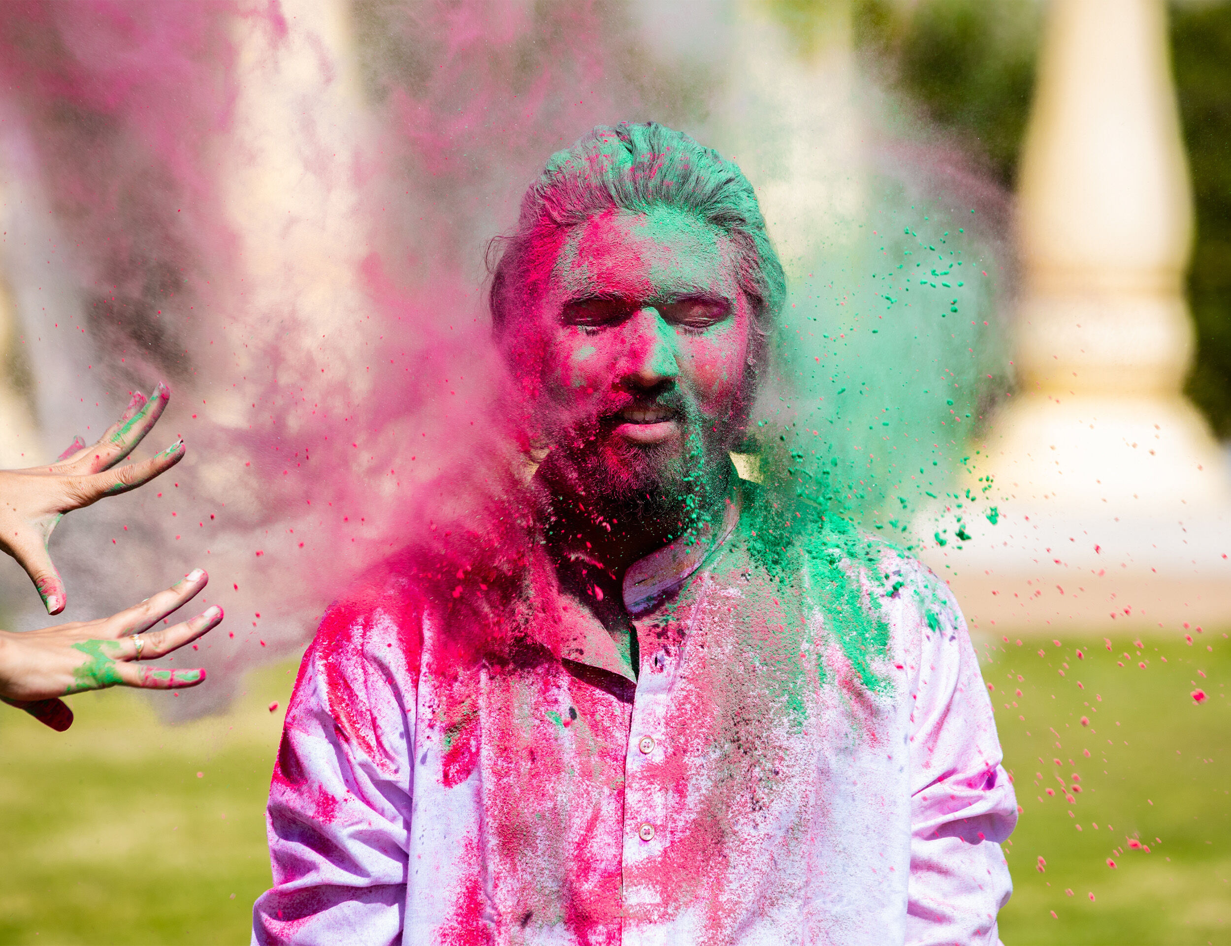people throwing colours on freinds  face 